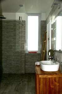 un bagno con lavandino, specchio e finestra di Le rose di Bino a Sestri Levante