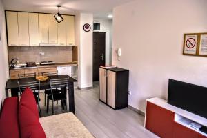 ein Wohnzimmer und eine Küche mit einem Tisch und einem Sofa in der Unterkunft Apartman Ljutovac in Gornja Toplica