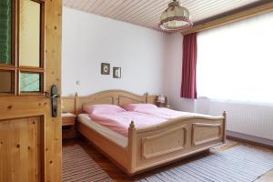 1 dormitorio con cama con sábanas rosas y ventana en Perbersdorfer Heuriger en Neuhofen an der Ybbs