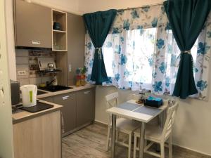 a kitchen with a table and chairs and a window at Studio Turquoise - Eforie Nord in Eforie Nord +5 photos