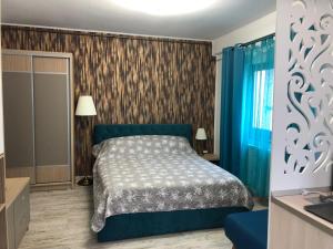 a bedroom with a blue bed and blue curtains at Studio Turquoise - Eforie Nord in Eforie Nord