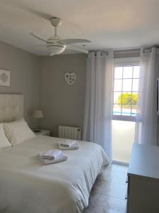 Un dormitorio con una cama blanca y una ventana. en Karin Palma Fiesta-Vallpineda-Sitges, en Sant Pere de Ribes 40 fotos más
