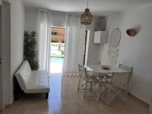 a white dining room with a table and chairs at Villapreciosa in Peñíscola