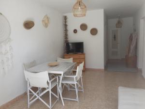 a dining room with a table and white chairs at Villapreciosa in Peñíscola