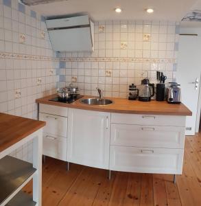 a kitchen with a sink and a counter top at Hering FeWo II Apartment Balcony in Wiek auf Rügen