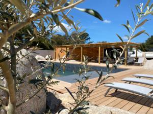 una terrazza in legno con sedie e una piscina di MAISON NEUVE PORTO VECCHIO a Porto Vecchio