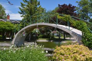 a bridge over a river with flowers on it at Isaiah Tubbs Resort & Conference Centre in Picton