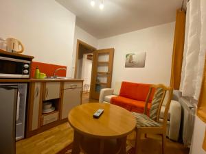クリニツァ・ズドルイにある2-pokojowe Apartamenty KAMIL Krynica-Zdrójの小さなリビングルーム(テーブル付)、キッチンが備わります。