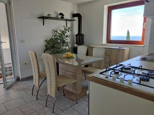 a kitchen with a table with chairs and a stove at Bellevue in Marezige +28 photos