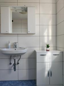 a white bathroom with a sink and a mirror at Bellevue in Marezige