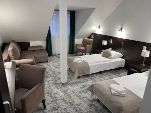a hotel room with two beds and a couch at Hotel Mużakowski in Łęknica +86 photos