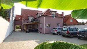 a house with cars parked in a parking lot at Gere Art&Exclusive Apartments in Harkány
