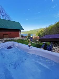 a bath tub filled with water in a yard at Sindy Wooden Apartments in Mavrovo