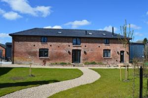 a large brick house with a gravel driveway at The Barn in Devizes