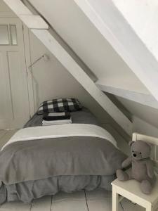a teddy bear sitting next to a bed in a attic at Vlasoven loft in Noordwijkerhout