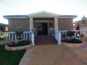 a house with a white railing and a porch at Chalet con Encanto y Piscina in Chiclana de la Frontera