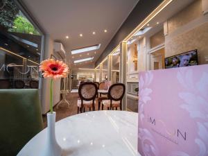 The Moon Boutique Hotel في صوفيا: مزهرية مع وردة على طاولة في مطعم