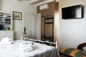 a room with a bed and a television on a wall at B&B Villa Lilla spiaggia inclusa e bici gratuite a San Benedetto del Tronto Camere con terrazzo e Colazione inclusa in San Benedetto del Tronto