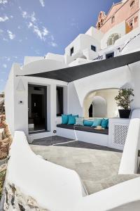 Casa blanca con sofá en el patio en Blue Art Caves, en Oia