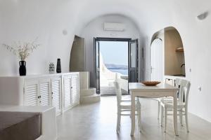 a kitchen and dining room with a table and chairs at Blue Art Caves in Oia