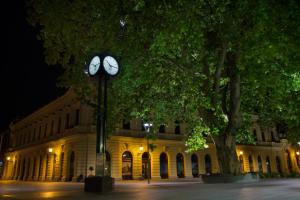 a clock tower in front of a building at night at Accommodation Zara in Vukovar