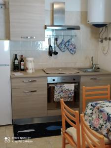 a kitchen with a stove and a sink and a table at Ostello ninin de ma' in Framura