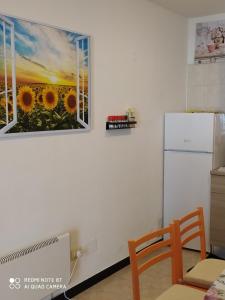 a kitchen with a picture of a sunflower on the wall at Ostello ninin de ma' in Framura