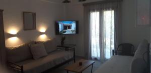sala de estar con sofá y TV en Residence Angeli, en Anaxos
