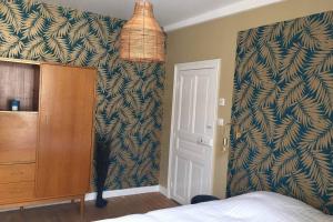 a bedroom with a bed and a dresser and a wall at Gîte« Le Pressoir » chez viticulteur en biodynamie in Avenay-Val-dʼOr