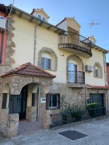 Apartamento rural FRAGARIA في Casas del Monte: منزل حجري قديم مع شرفة