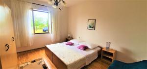 een slaapkamer met een bed met paarse kussens erop bij Karla's holiday home in Debeljak