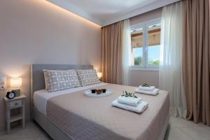 a bedroom with a large bed with towels on it at Lia's Home One in Mantoúkion