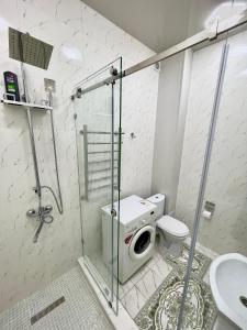 uma casa de banho com um WC e um chuveiro com uma máquina de lavar roupa em Amir Temur Apartment in center After renovation em Tashkent