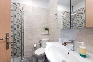a bathroom with a sink and a toilet and a shower at Lia's Home One in Mantoúkion +33 photos