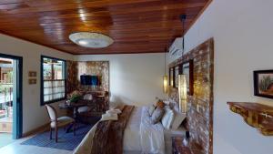 a room with a bed and a couch and a table at Pousada Quatro Estações in Bichinho