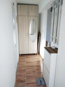 a kitchen with a white cabinet and a wooden floor at Apartman Martinovic in Kladovo