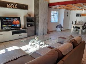 ein Wohnzimmer mit einem Sofa und einem TV in der Unterkunft Holidays Homes Il Folletto in Quartino