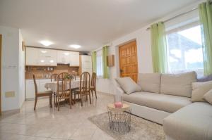 a living room and kitchen with a couch and a table at Flower house Podčetrtek in Podčetrtek