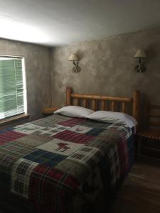 a bedroom with a bed with a quilt on it at Riverbend Resort in South Fork