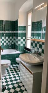 zieloną i białą łazienkę z umywalką i toaletą. w obiekcie Apartment Italian Charm w mieście Ghiffa
