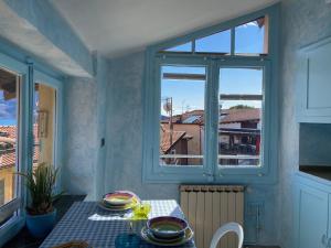 Zimmer mit einem Tisch und einem Fenster in der Unterkunft Apartment Italian Charm in Ghiffa
