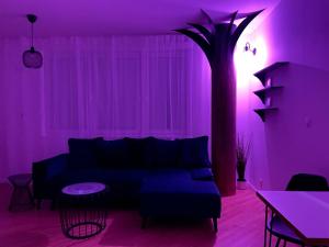 a purple living room with a couch and a palm tree at BeTree in Bratislava