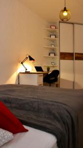 a bedroom with a bed and a desk with a laptop at BeTree in Bratislava
