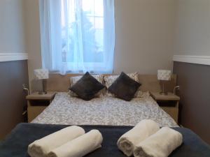 a bedroom with a bed with two pillows on it at GRAND VILLA USTKA- Marmonoli in Ustka