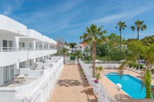 an aerial view of the resort with a swimming pool and palm trees at Olive Beach Apartamentos in Port d'Alcudia +32 photos