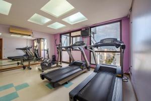 ein Fitnessstudio mit Laufbändern und Crosstrainern in einem Raum in der Unterkunft Apartamento Beverly Hills Studio in Porto Alegre