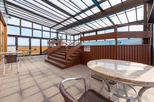 Großes Zimmer mit einem Tisch, Stühlen und Fenstern in der Unterkunft Apartamento Beverly Hills Studio in Porto Alegre