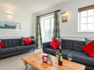 a living room with a couch and a table with wine glasses at Ashwood in Weymouth