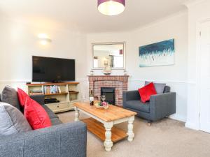 a living room with a fireplace and a tv at Ashwood in Weymouth