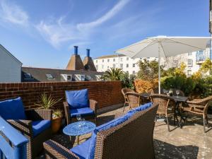 a patio with chairs and tables and an umbrella at Ashwood in Weymouth